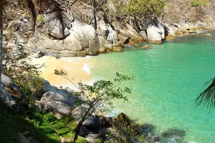 Klein afgelegen zandstrand met turquoise water bij Los Arcos.